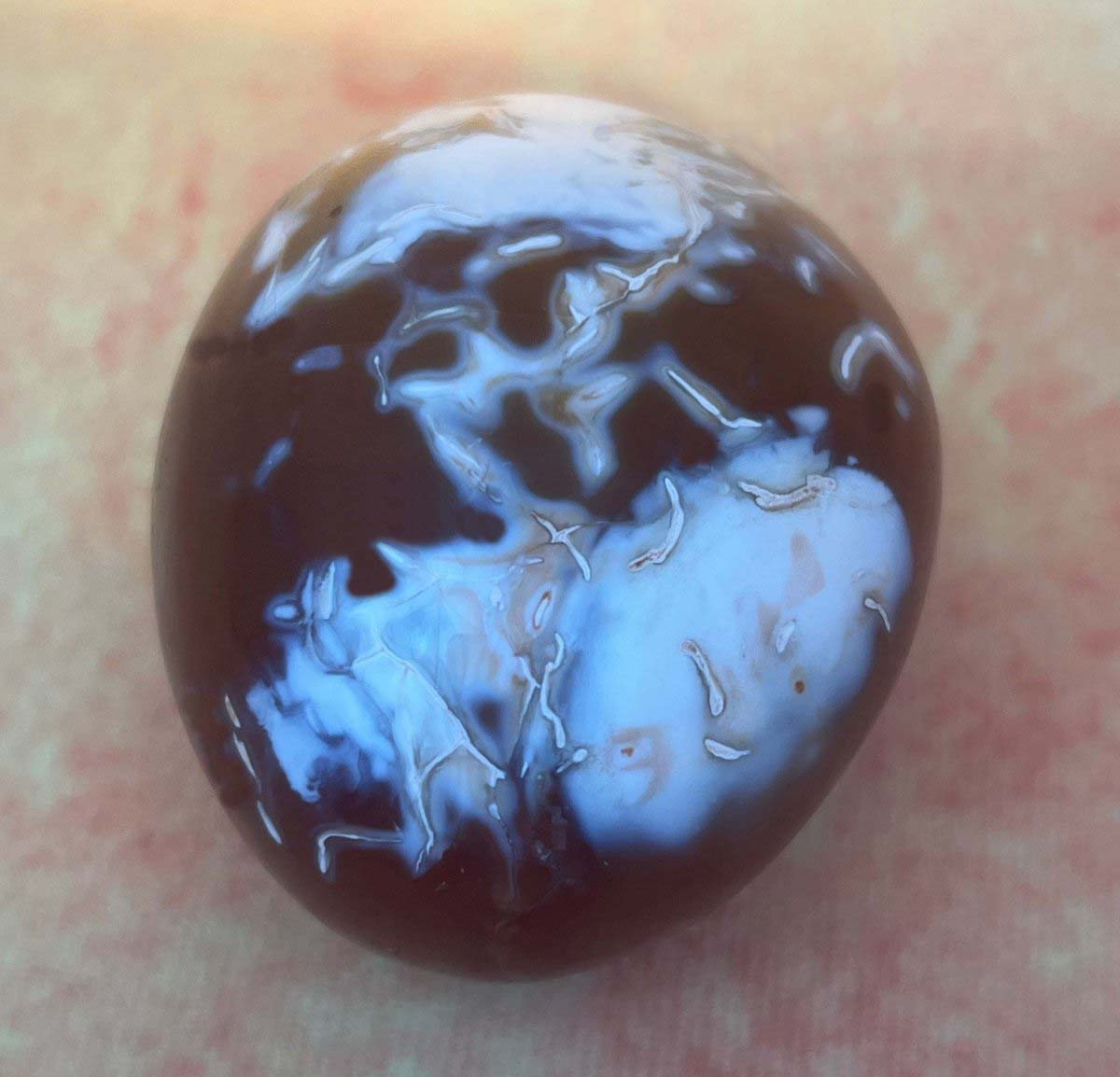 Real carnelian stone showing two large white spots that are being separated.  