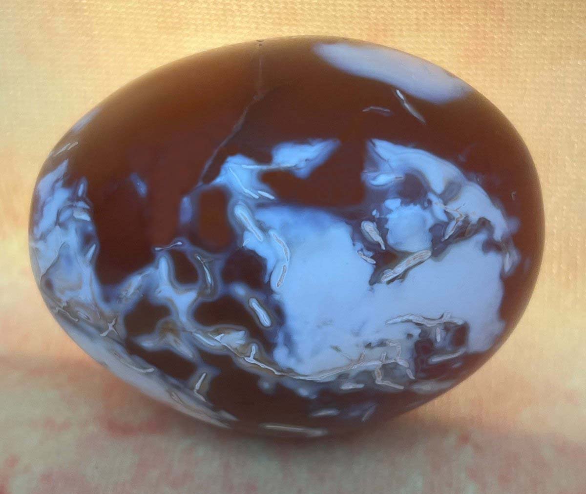 Red carnelian agate palm stone with unique white spots.